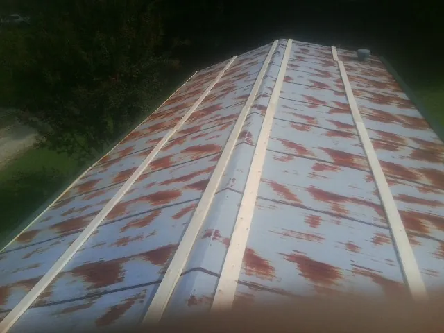 Rusted metal roof panels with new wood purlins before replacement — Storm Damage Roof Repair in Angola by Roofing Brothers